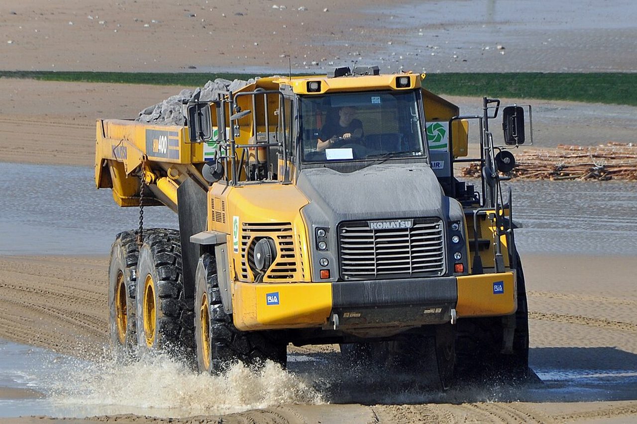 Komatsu HM400 articulated dumper hauling through sand and water